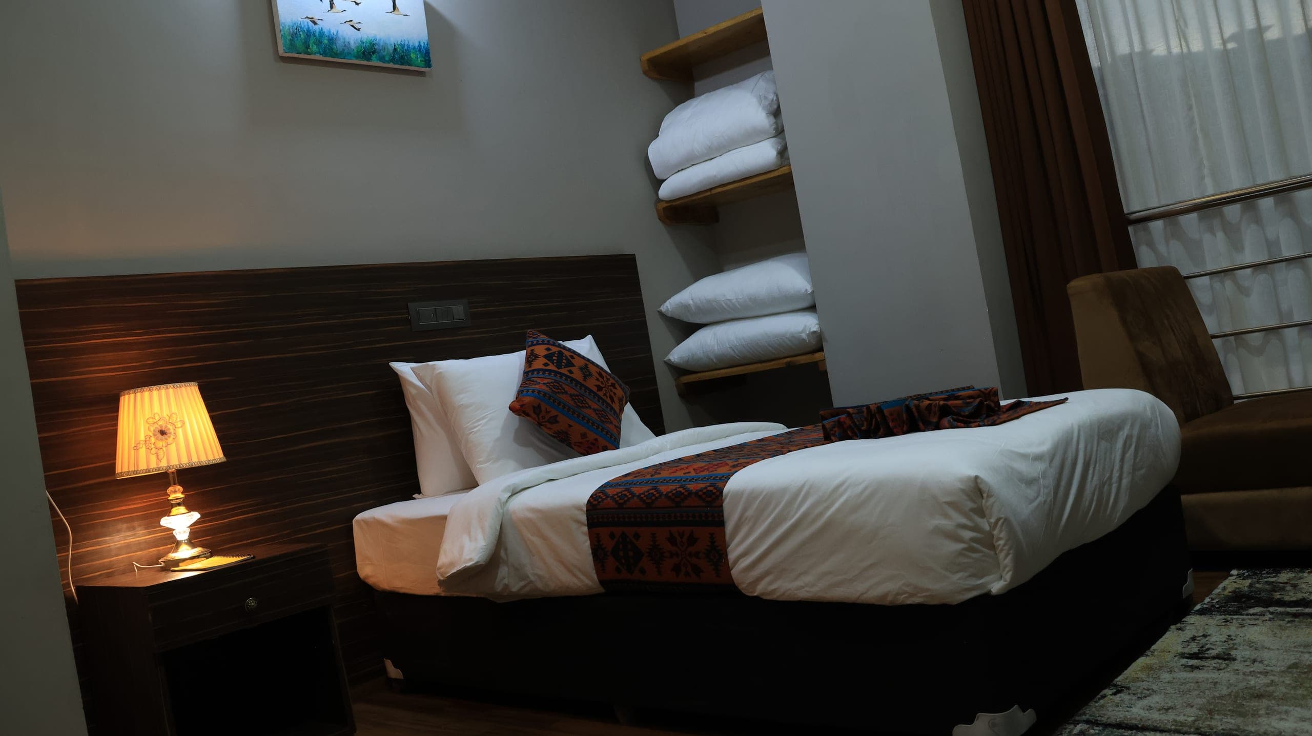 Deluxe Single room with a king-size bed and bedside lamp